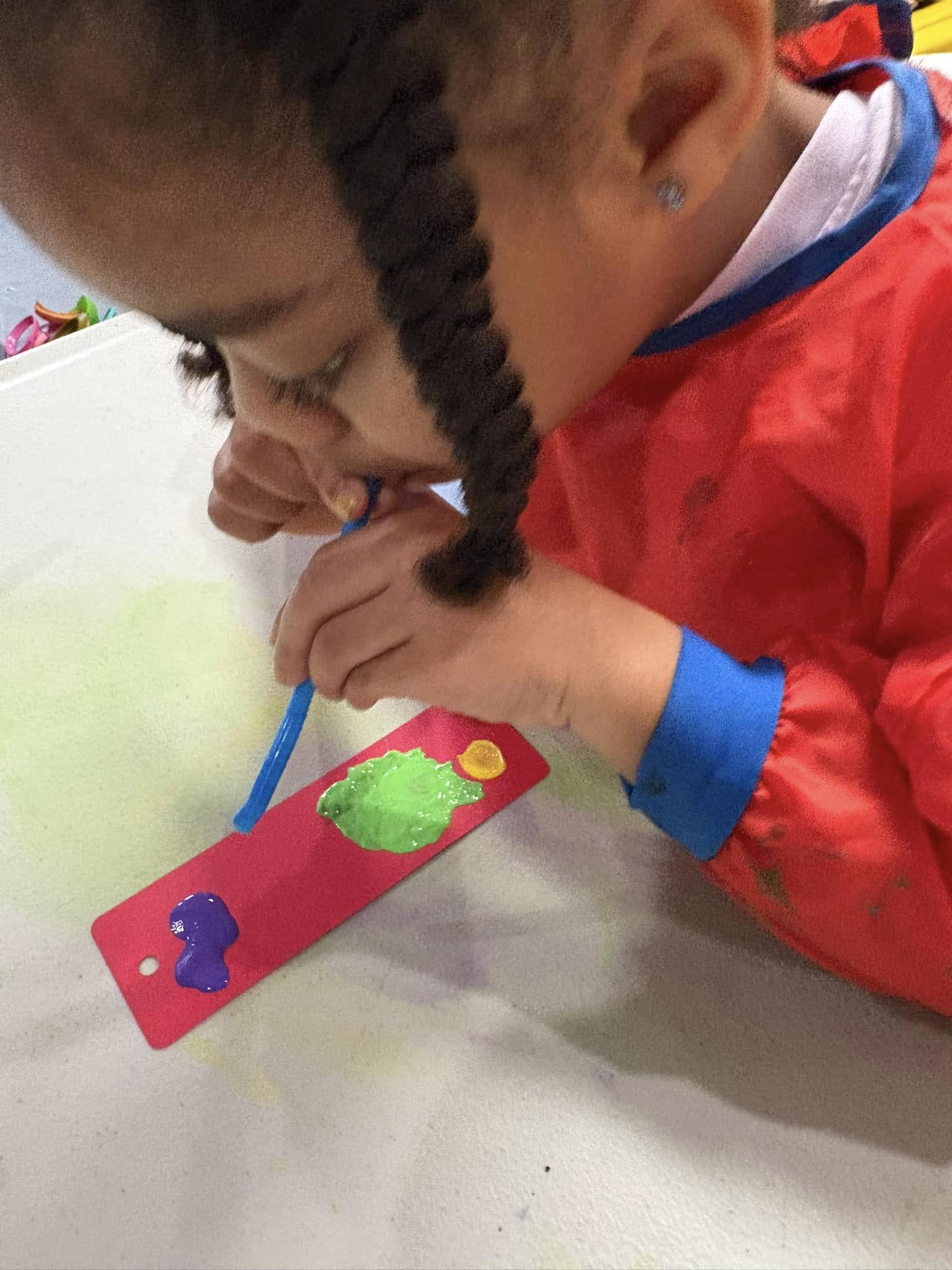 Young child focused on painting with a brush